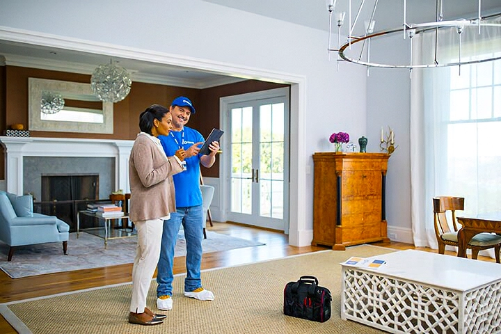 HMC explains how pricing and payments work to homeowner in her living room