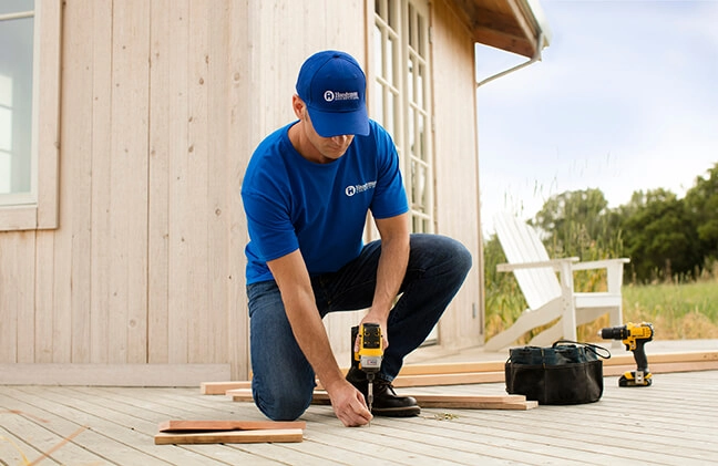 A photo of a Handyman Connection worker working on a backyard deck