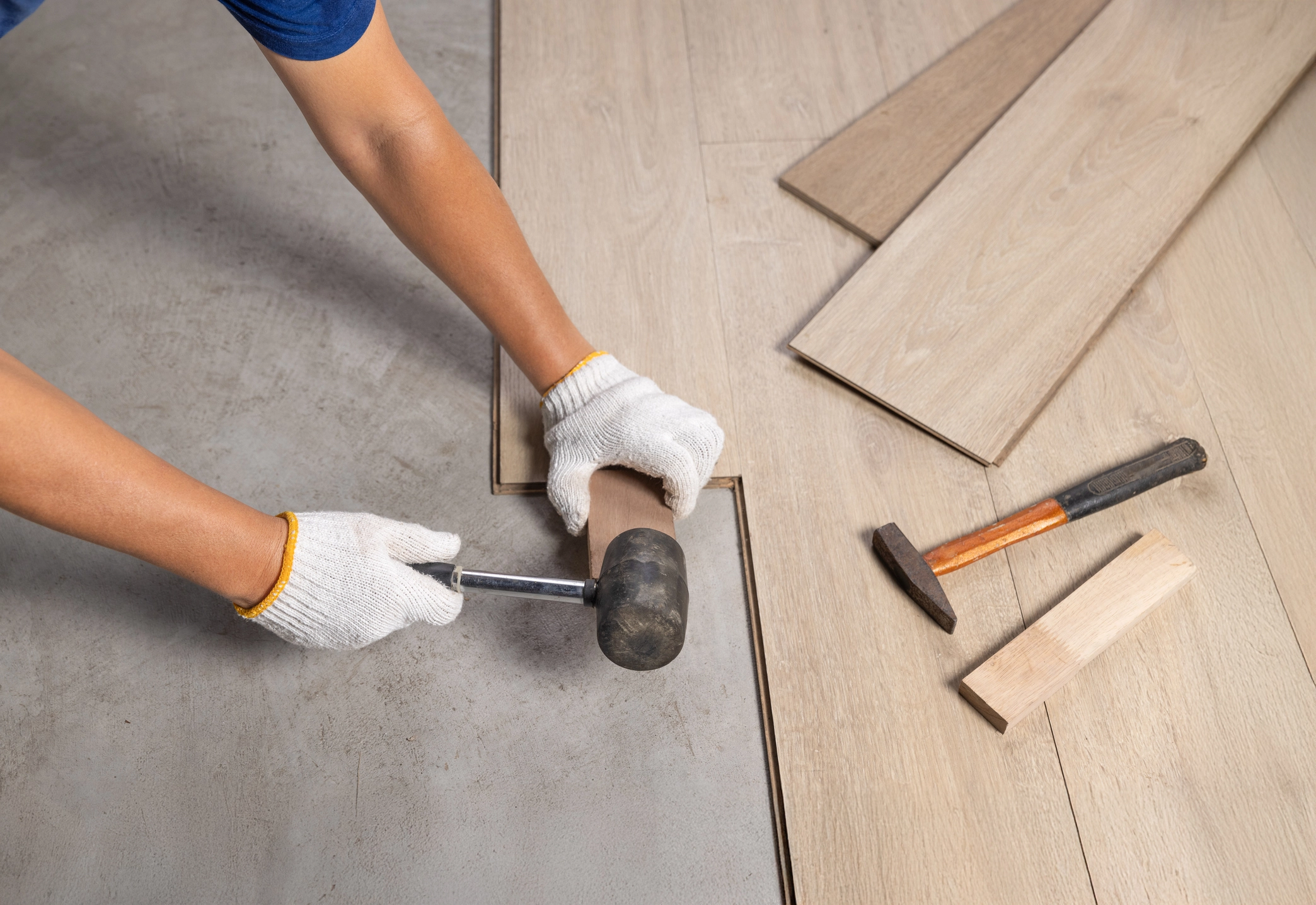Close up photo of worker using mallet to fit floring pieces together