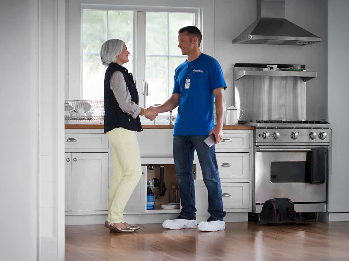 Customer and HMC worker shake hands in new kitchen with new flooring