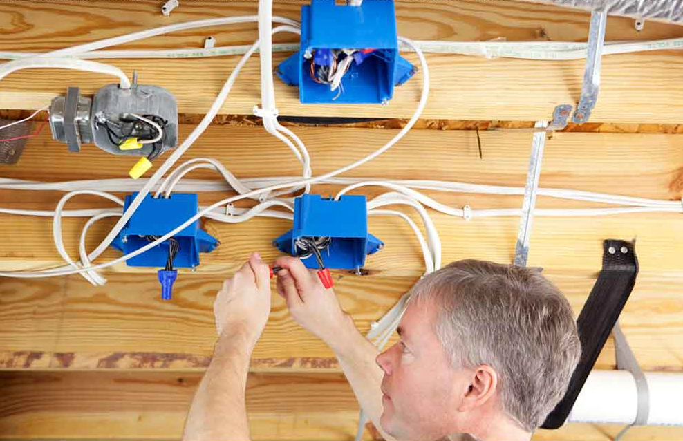 A photo of a Handyman Connection worker rewiring in a basement