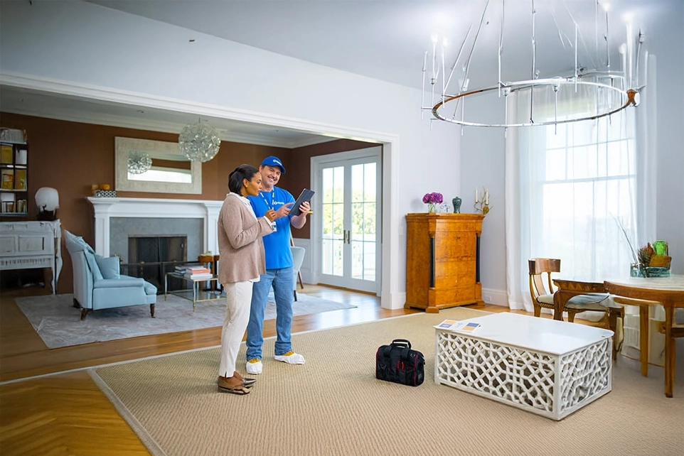 A photo of a Handyman Connection worker reviewing plans with homeowner