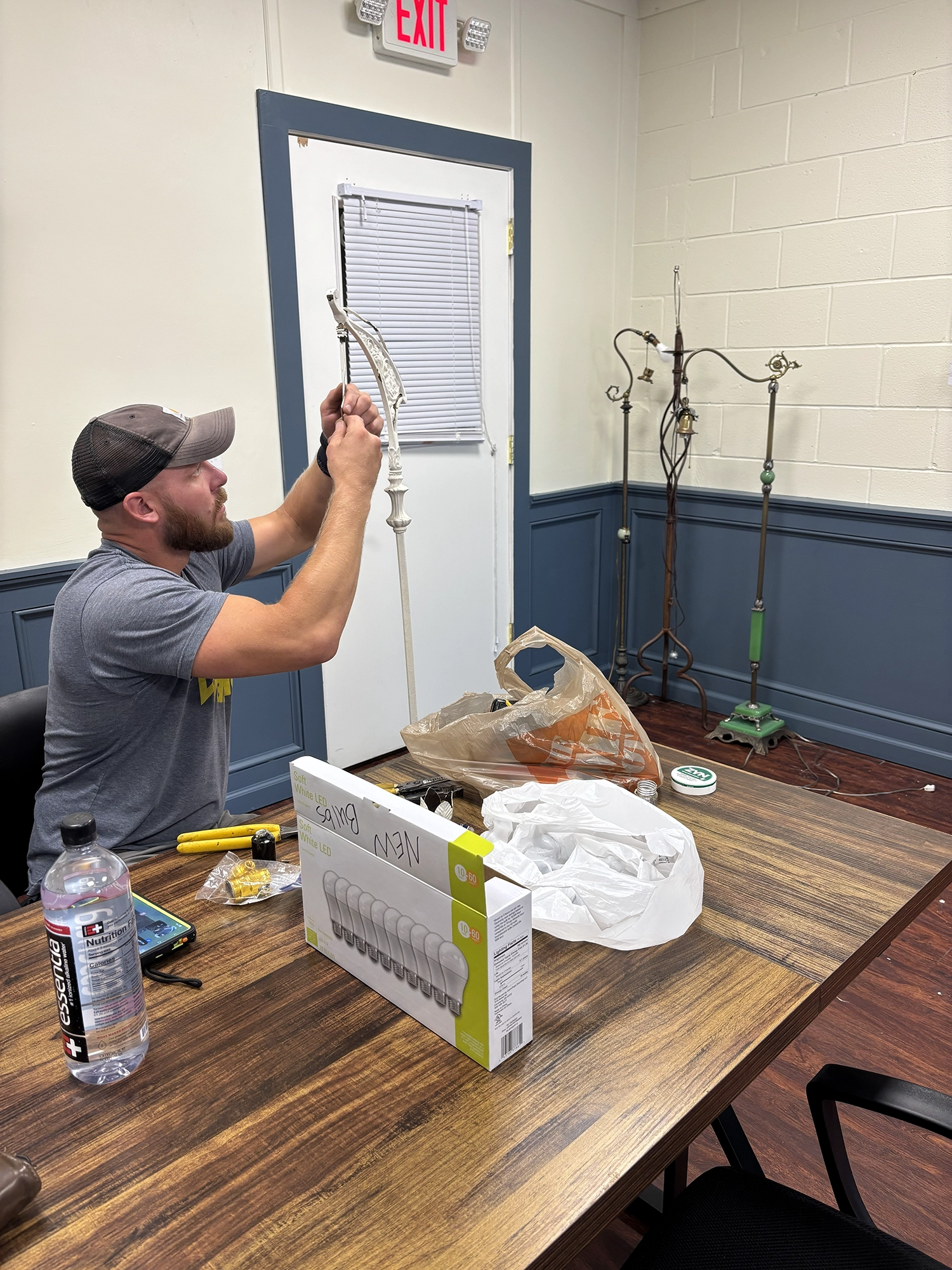 Handyman adjusting a light fixture in homeowners living room