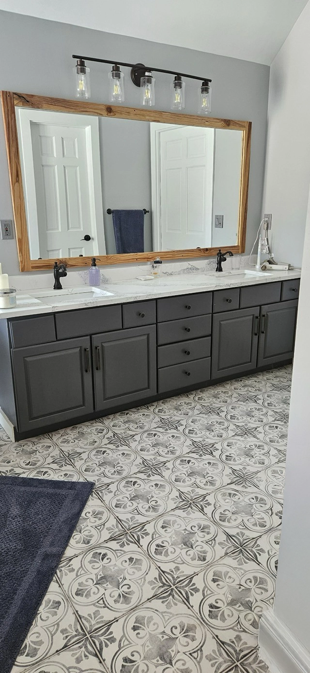 A photo of a a newly remodeled bathroom sink, tile, and mirror