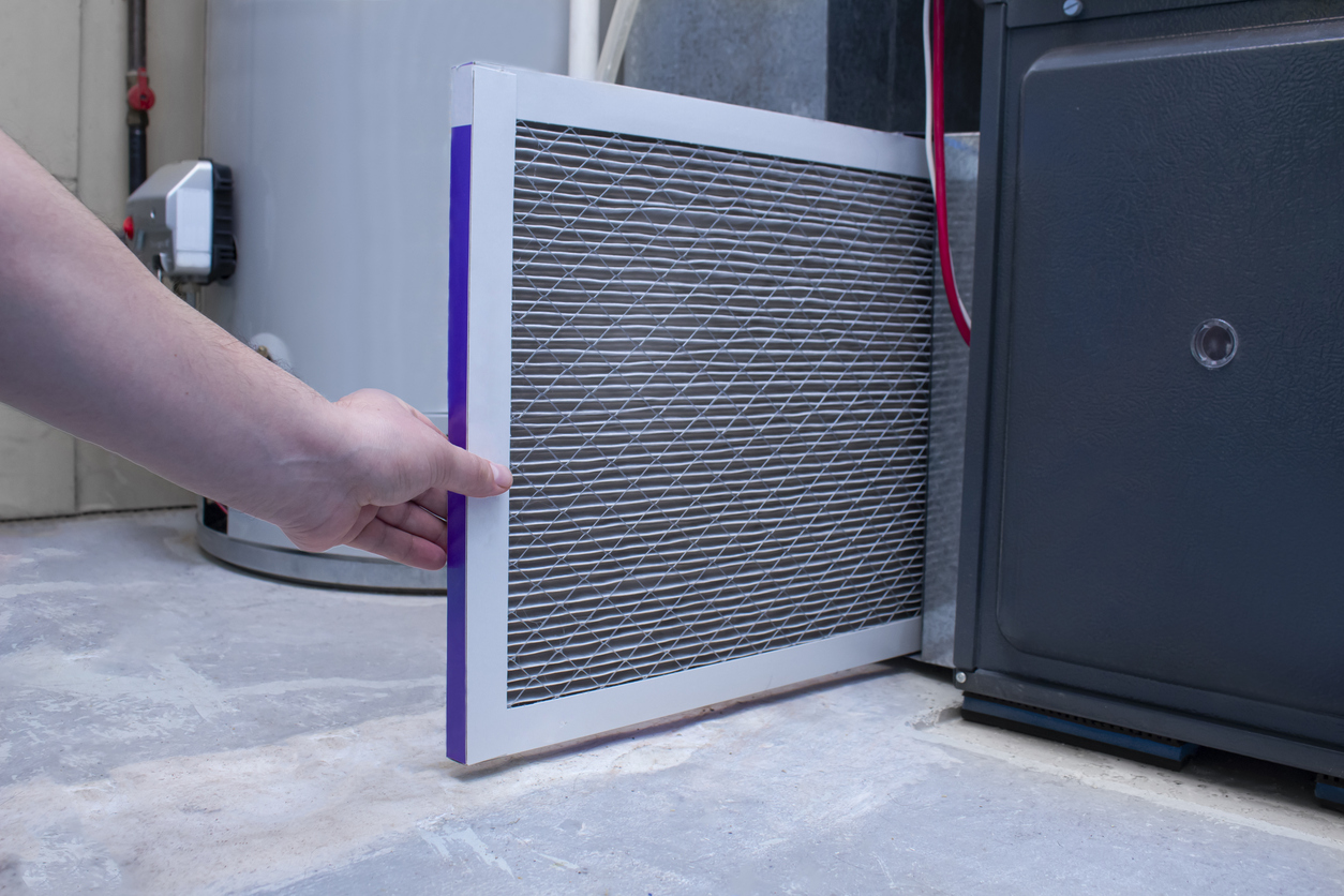 A photo of a furnace filter being replaced